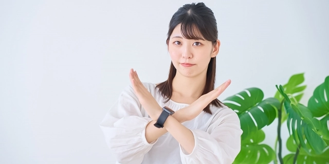 女性がバツ印をジェスチャーする