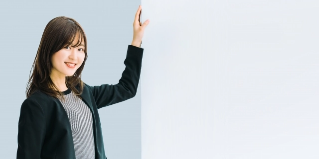 女性が壁に手をつけている